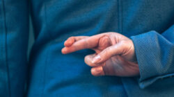 fingers crossed behind back