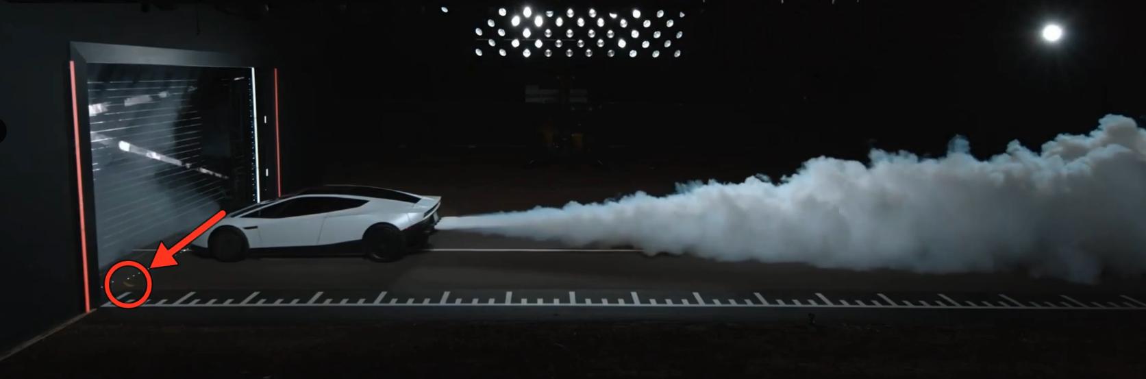 Side view of the white Tesla Roadster on a dark test track beside a ruler-style distance marker, with rocket exhaust billowing out behind it and a red arrow and circle at the far left marking a small banana on the ground